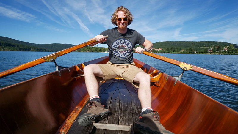 Row boat ride in Schluchsee in Germany's Black Forest with Nomadic Samuel doing the rowing with smile and sunglasses 