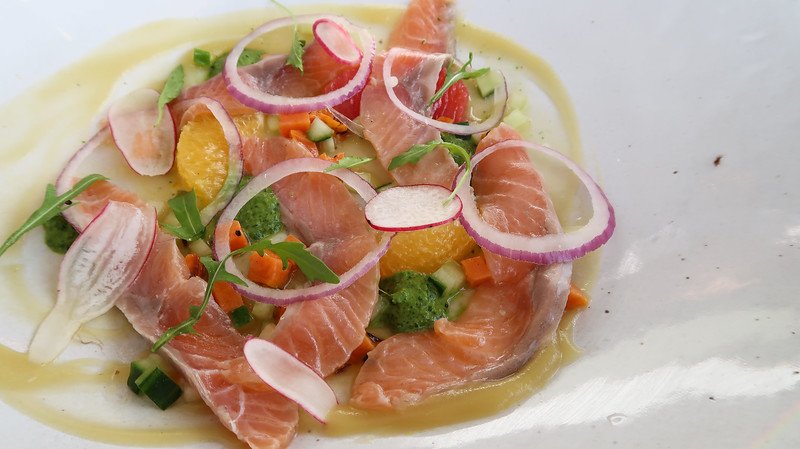 Colorful salmon ceviche garnished with red onion, citrus segments, microgreens, and diced vegetables at The Granary Café inside The Silo Hotel in Cape Town, South Africa