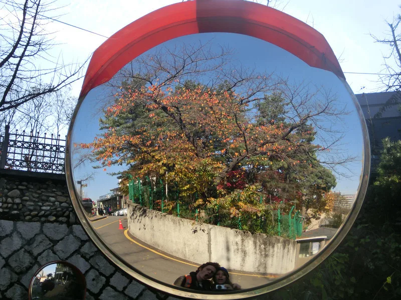 Samuel and Audrey on their way to Namsan, Seoul, Korea looking in the street mirror