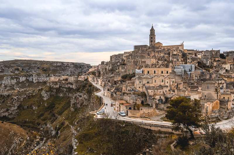Scenic views of Matera from a far away vantage point highlighting ancient architecture and dramatic cliff drops in Italy Scenic views of Matera from a far away vantage point highlighting ancient architecture and dramatic cliff drops in Italy