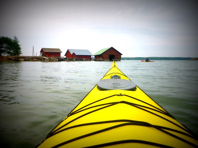 Sea kayaking in the Kimitoön Archipelago with our yellow kayak pointing the way to some unique red buildings 