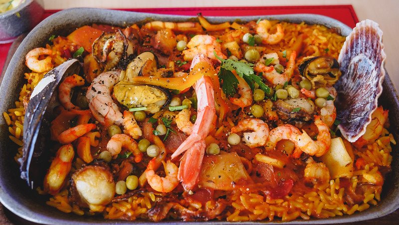 Colorful seafood paella served at El Náutico Cantina in Puerto Madryn, Patagonia, Argentina, featuring shrimp, mussels, scallops, peas, peppers, and rice. A must-try local dining experience after exploring Peninsula Valdes attractions