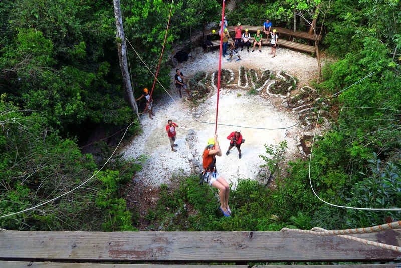 Traveler experiencing a thrilling jungle bungee swing at Selvatica adventure park near Playa del Carmen, Mexico