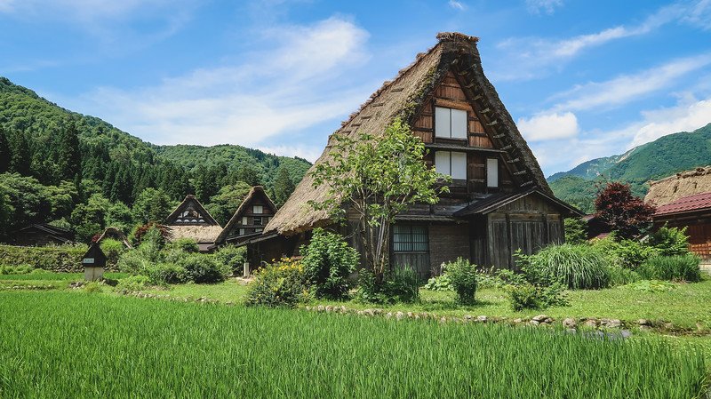 Shirakawa-go can be visited on a day trip from Takayama, Japan to visit traditional Japanese farmhouses in a beautiful rural setting with mountain backdrop 
