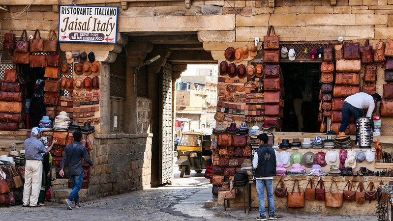 Shopping for souvenirs in Jaisalmer with hats and purses and other real and fake leather goods on sale in India