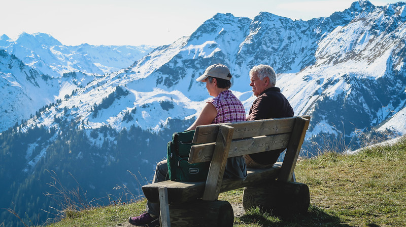 Snow on the Alps in September with visitors wearing t-shirts sitting on a park bench. Quite the contrast indeed in Tirol, Austria!