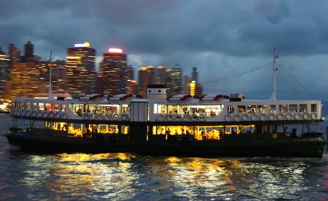 Star Ferry crossing at night in Hong Kong with distinct motion blur on the water 
