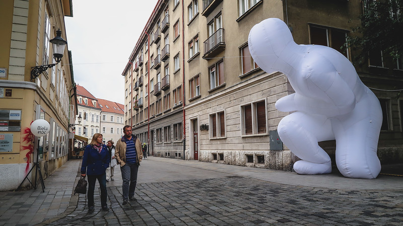 Street scene in Bratislava's Old Town with unique art installation and pedestrians strolling onwards in Slovakia Street scene in Bratislava's Old Town with unique art installation and pedestrians strolling onwards in Slovakia