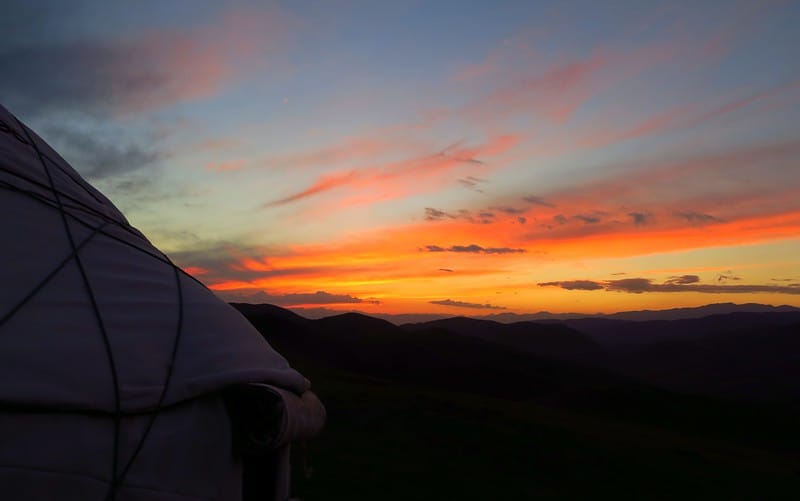 Sunset at our yurt camp with stunning mountain views and fiery clouds off in the distance in Kyrgyzstan 