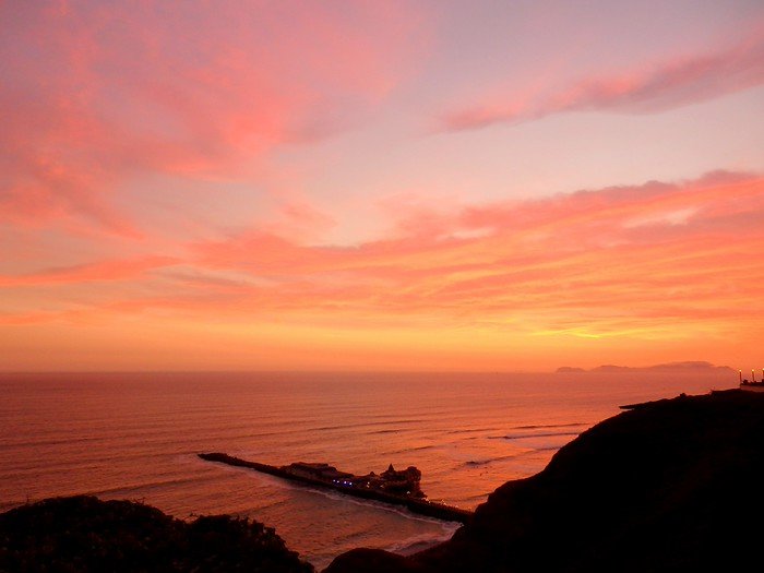 Sunset in Lima, Peru with fiery skies and incredible views and from a high vantage point overlooking the coast