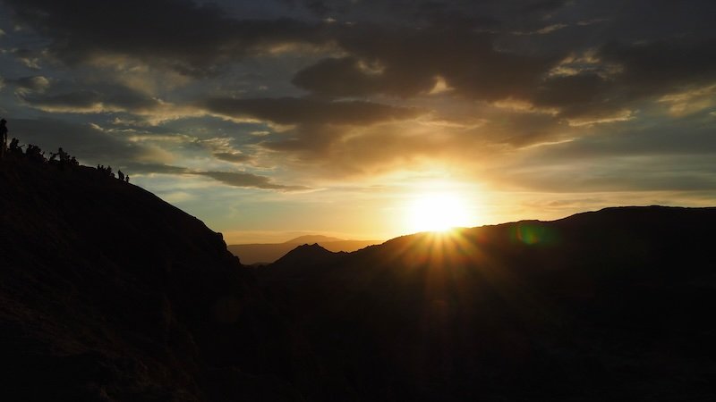 Golden sunset over the Valley of the Moon in Atacama Desert, Chile, with silhouettes of visitors admiring the view Golden sunset over the Valley of the Moon in Atacama Desert, Chile, with silhouettes of visitors admiring the view