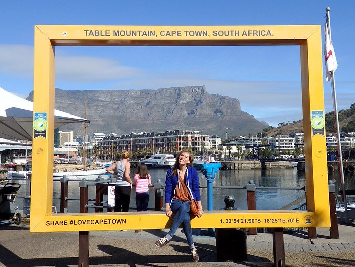 Table Mountain as seen from the V&A Waterfront in Cape Town, South Africa with a smiling That Backpacker Audrey Bergner as the model 