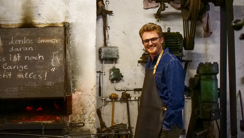 Taking part in a forging workshop at Burgenlandschmiede is a smiling Nomadic Samuel ready to get to work and learn some new skills for the day