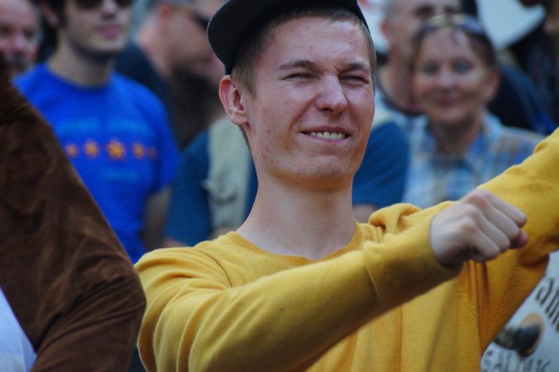 Young man enjoying a lively medieval street festival in Tallinn, Estonia during a day trip from Helsinki