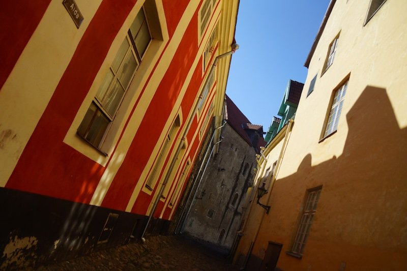 Colorful medieval alleyway with red and yellow buildings in Tallinn Old Town, Estonia, a UNESCO World Heritage architectural landmark