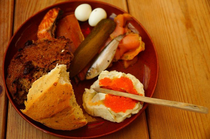 Neptune’s Feast platter at Olde Hansa medieval restaurant in Tallinn, Estonia, featuring smoked fish, salmon, bread, quail eggs, pickles, and caviar-topped spread