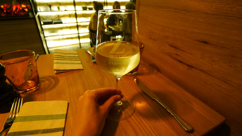 Tasting German wines at 51° Restaurant & Weinbar in Freyburg with That Backpacker Audrey Bergner holding a glass in front of her