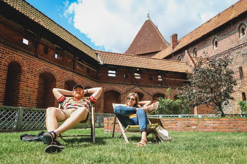 That Backpacker and Nomadic Samuel relaxing on chairs during our day trip from Gdansk to Malbork to visit the world famous castle in Poland