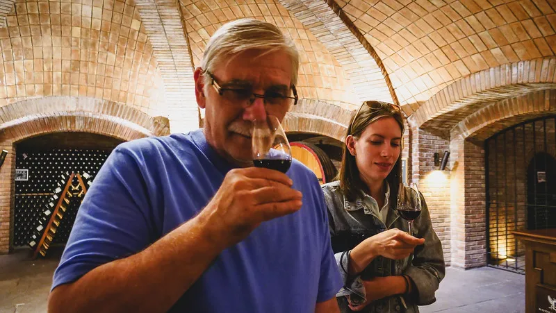 That Backpacker Audrey Bergner and Daniel Bergner doing a wine tasting at Bodegas Lopez in Mendoza sniffing the wine in the cup