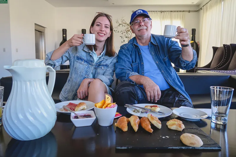 That Backpacker Audrey Bergner and Daniel Bergner having breakfast at Bodegas Lopez before our tour holding up cups of coffee and enjoying a spread of food 