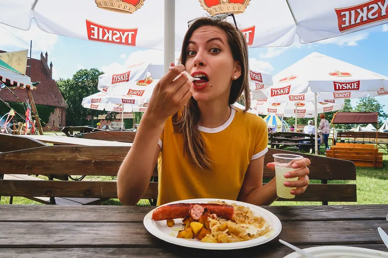 That Backpacker Audrey Bergner eating hearty Polish food at Malbork Castle in Poland