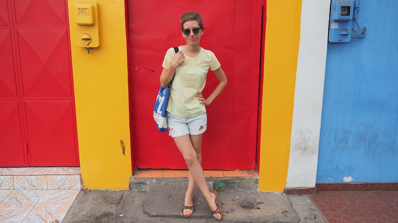 That Backpacker Audrey Bergner enjoying a colorful stop in Arica, Chile posing by a multi-color building with a distinct door 
