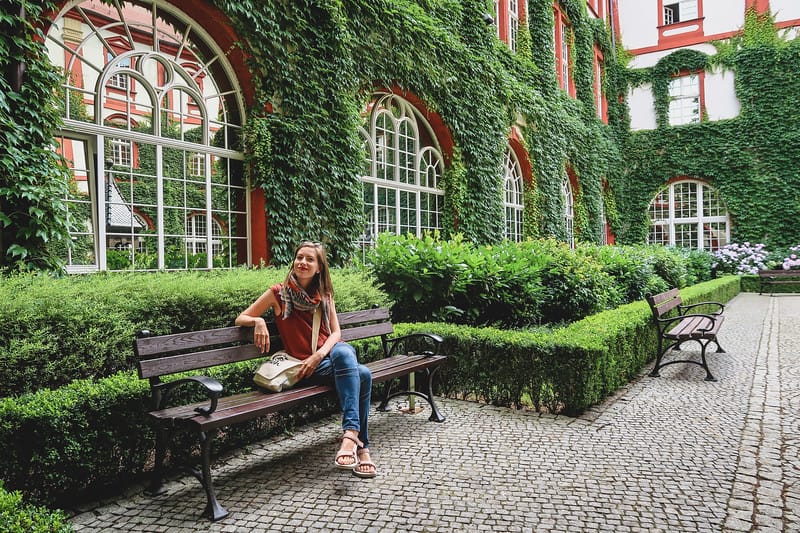 That Backpacker Audrey Bergner enjoying a sit down park bench break at the 'secret' courtyard at the Ossolineum Library in Wroclaw, Poland That Backpacker Audrey Bergner enjoying a sit down park bench break at the 'secret' courtyard at the Ossolineum Library in Wroclaw, Poland