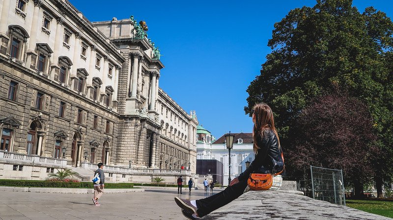 That Backpacker Audrey Bergner sitting on a stone ledge outside Hofburg Palace in Vienna, Austria, relaxing under a clear blue sky after a day of sightseeing That Backpacker Audrey Bergner sitting on a stone ledge outside Hofburg Palace in Vienna, Austria, relaxing under a clear blue sky after a day of sightseeing