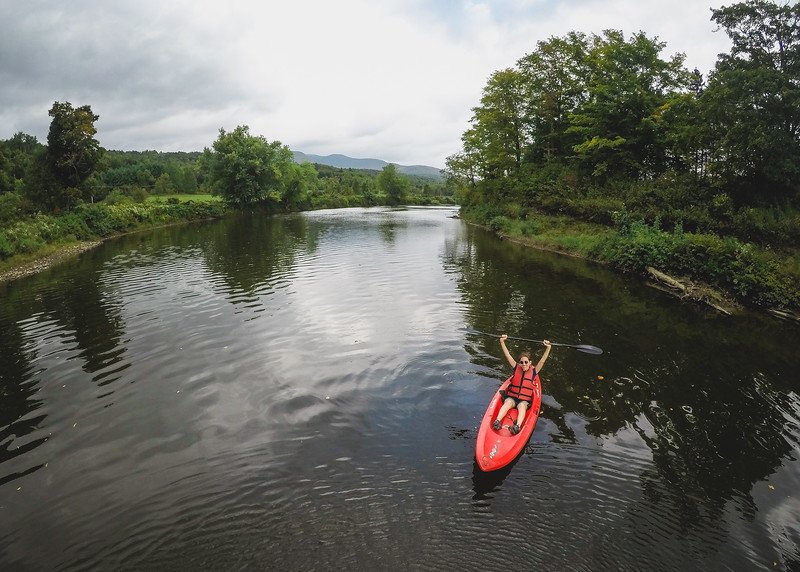 That Backpacker Audrey Bergner kayaking on the peaceful Missisquoi River surrounded by lush green forest at Au Diable Vert in Sutton, Quebec, enjoying an adventurous getaway in the Eastern Townships