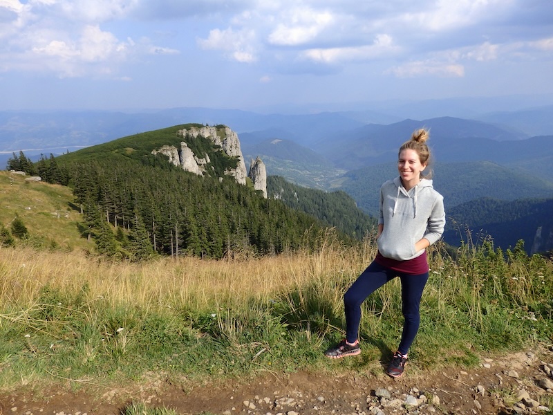 That Backpacker Audrey Bergner posing at the top of the mountain in Romania wearing a warm hoody to stay toasty 
