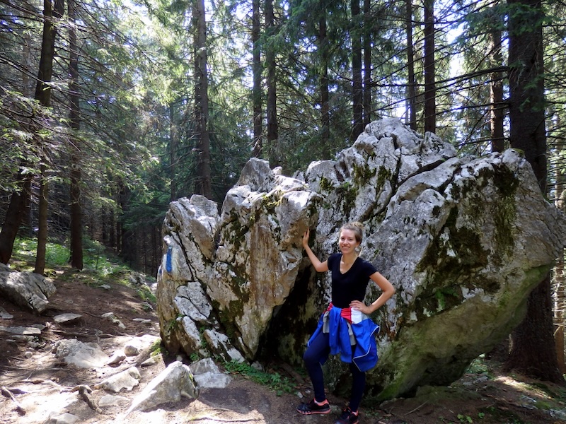 That Backpacker Audrey Bergner posing by a giant natural rock formation on her hike in Romania 