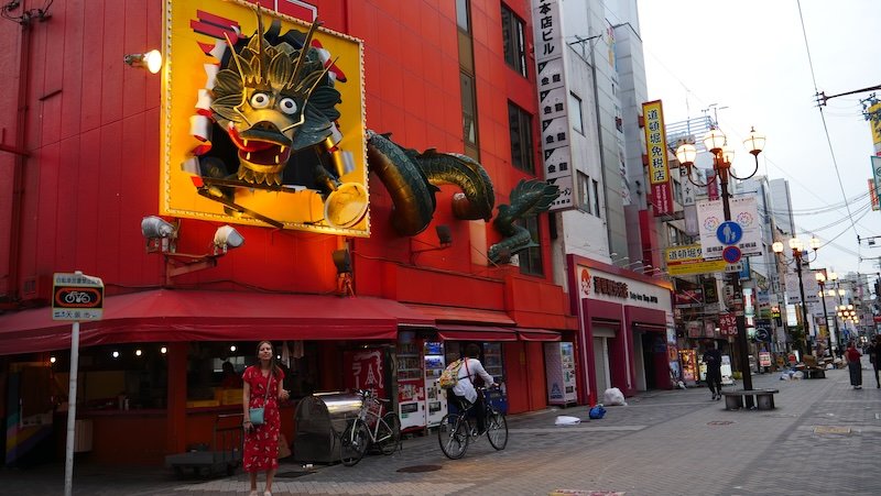 That Backpacker Audrey Bergner posing outside by fascinating storefronts in Dotonbori, Osaka, Japan 