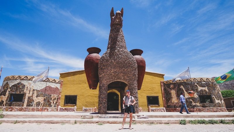 That Backpacker Audrey Bergner stopping to pose by quirky landmarks in this case a large llama on a day trip in Jujuy, Argentina from Salta 