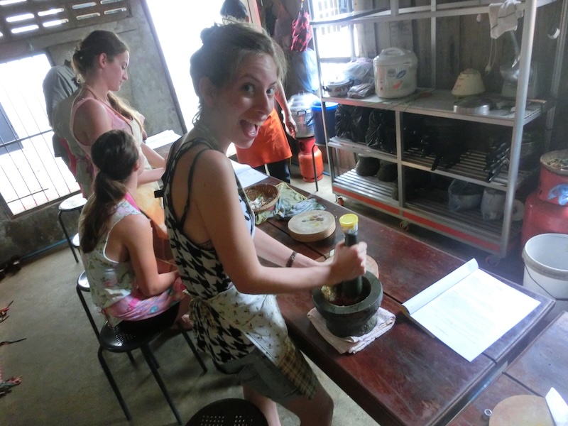 That Backpacker Audrey Bergner using pestel and mortar to pound Cambodian spices into curry paste in Battambang, Cambodia 