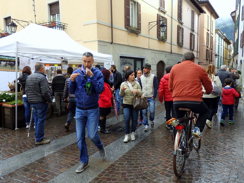 The bresaola food festival in Italy with busy streets full of pedestrians including families and even a few riding bicycles