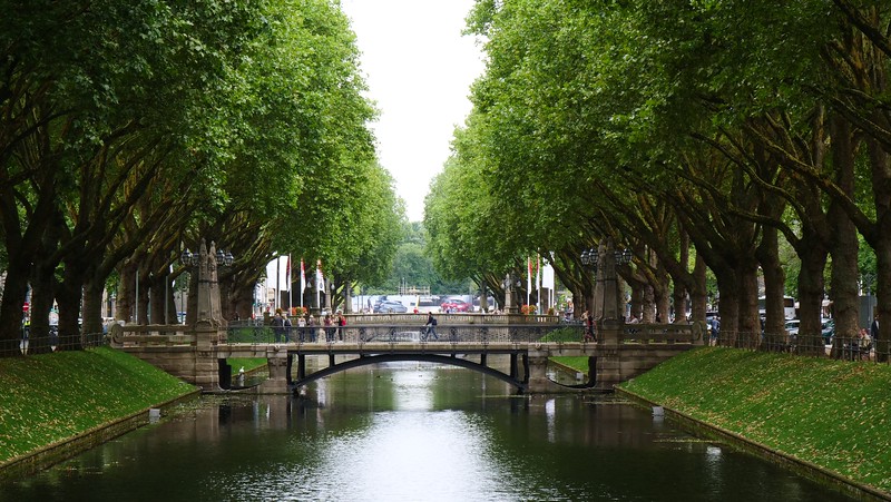 The canal that runs down the middle of Königsalle in Düsseldorf is a popular place for pedestrians to cross the bridge in Germany