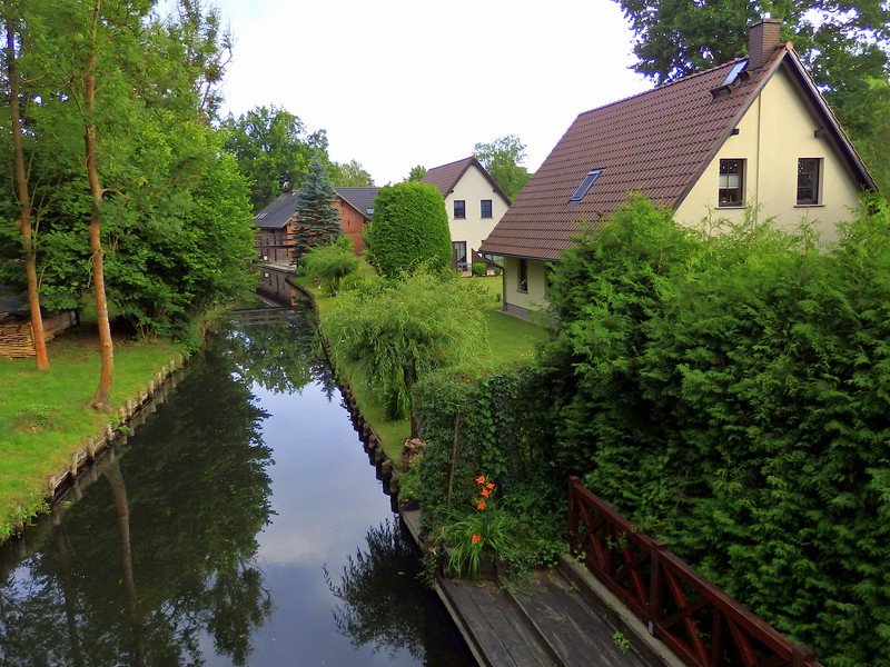 The canals that run through Spreewald, Germany are narrow and dotted with homes and cottages on the side 