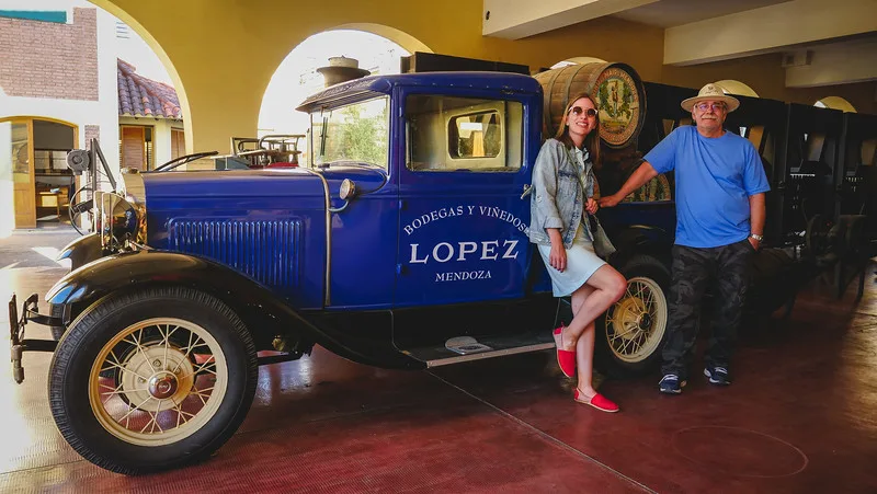 The end of our full day wine tour at Bodegas Lopez in Mendoza with That Backpacker Audrey Bergner and Daniel Bergner posing by the vintage truck