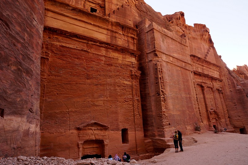The Facades Street lined with buildings carved out of the red rock are grand and imposing as indicated by the tiny size of people next to it