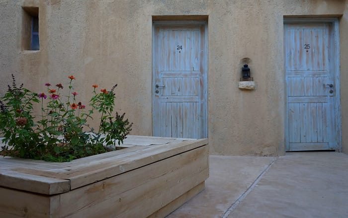 The Feynan Ecolodge in Jordan room views from an outside perspective with flower garden nearby 