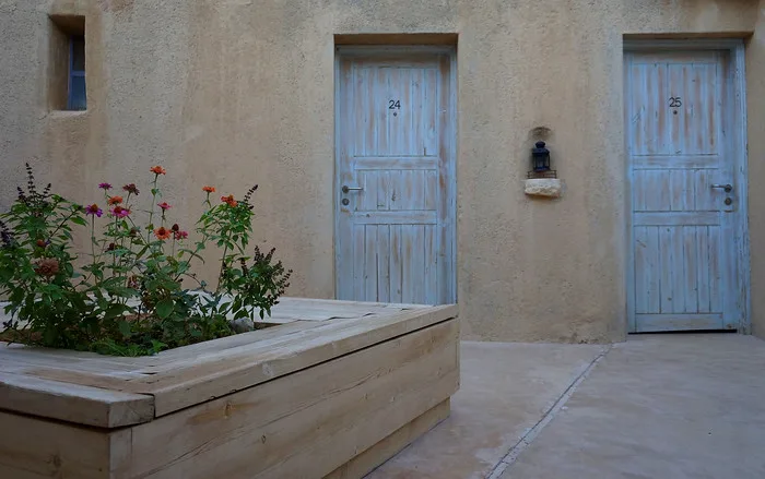 The Feynan Ecolodge in Jordan room views from an outside perspective with flower garden nearby 
