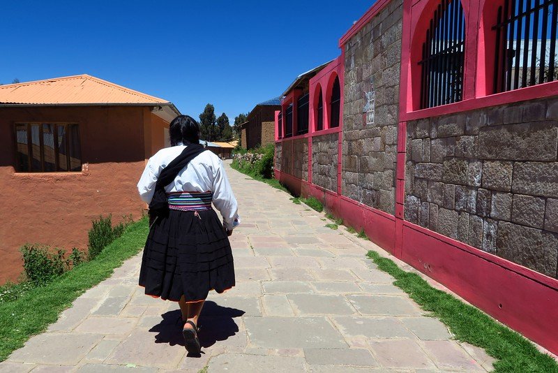 The host of our homestay on Lake Titicaca wearing traditional Peruvian attire and leading us to our guesthouse for the evening in Peru