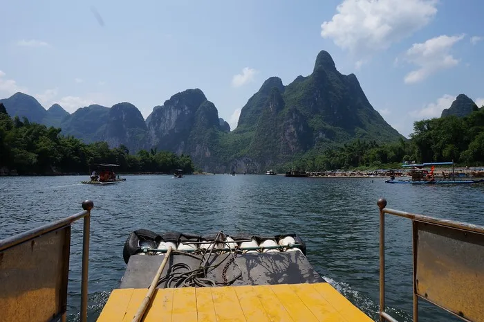 The journey down the Li River scenic views from the back of the boat with Karst mountain views of in the distance