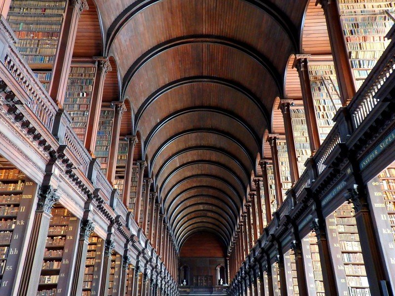 The library at Trinity College in Dublin, Ireland with its gorgeous and distinct interior design and balcony with a beautiful book display 