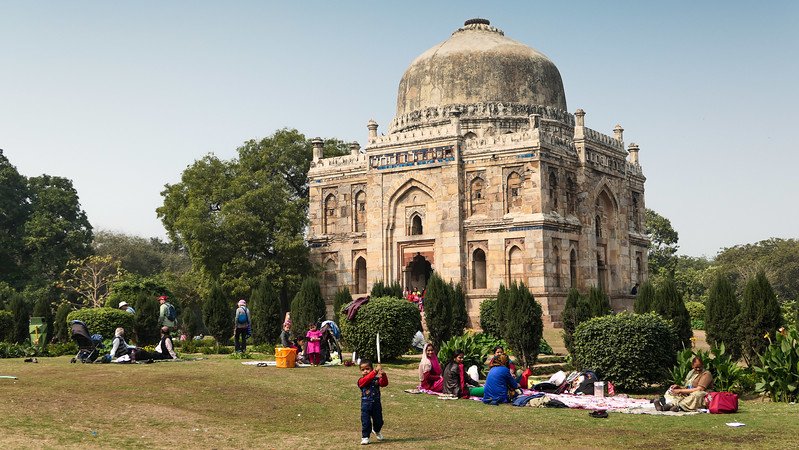 The Lodhi Gardens in Delhi with families enjoying picnics and even a bit of cricket around the green areas in India