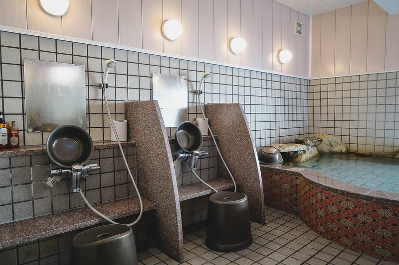 The onsen at Ryokan Seiryu in Takayama, Japan with its showering stations and onsen bath area The onsen at Ryokan Seiryu in Takayama, Japan with its showering stations and onsen bath area