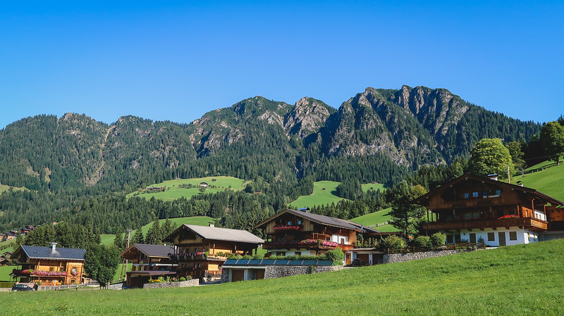 The scenery in the outskirts of Alpbachtal, Tyrol with traditional Austrian houses amidst a spectacular mountain backdrop