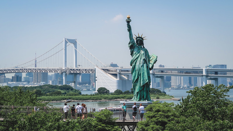 The Statue of Liberty and Rainbow Bridge as seen from Odaiba, Japan is a major landmark and tourist attraction for visitors The Statue of Liberty and Rainbow Bridge as seen from Odaiba, Japan is a major landmark and tourist attraction for visitors