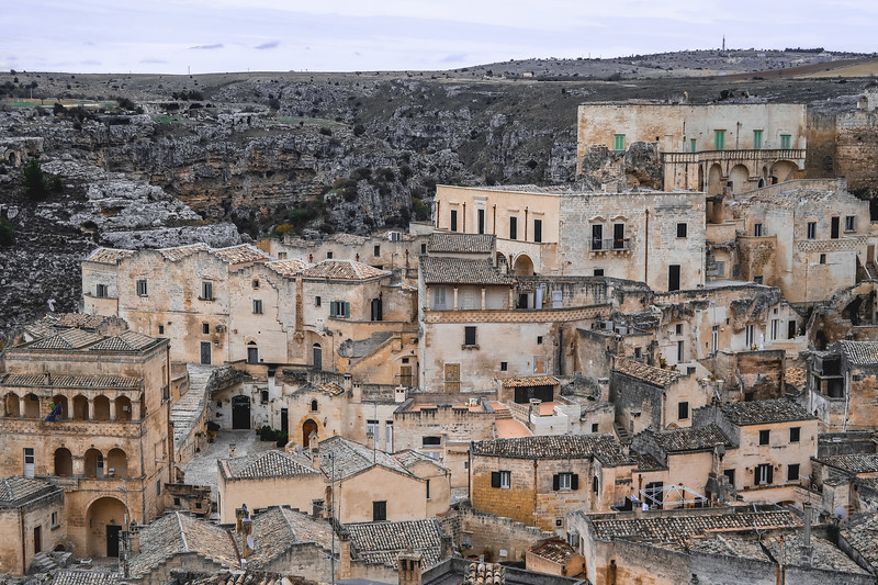 The stone constructions of Matera, Italy with rugged landscape in the background The stone constructions of Matera, Italy with rugged landscape in the background