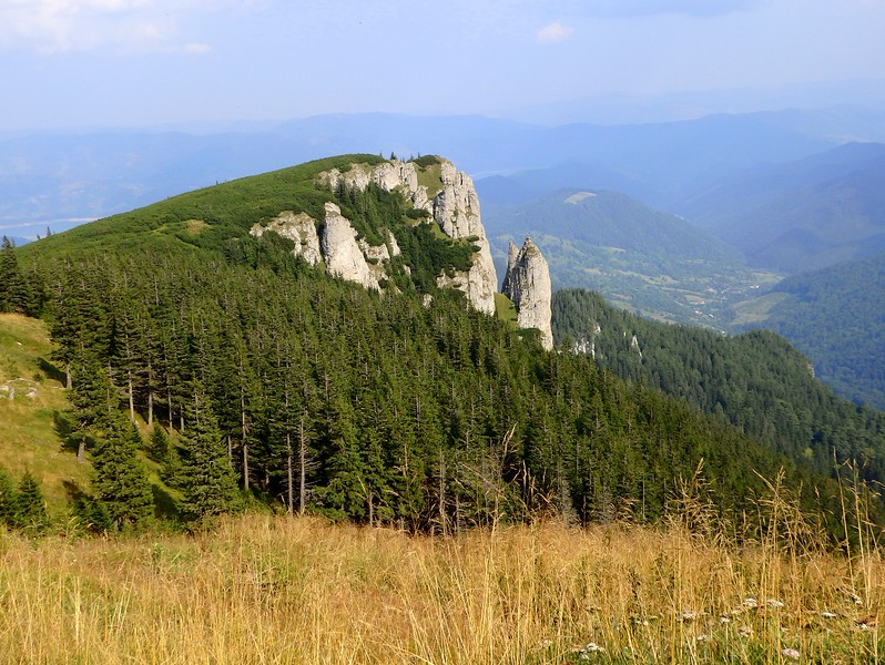 The views when hiking in Romania with mountain ranges sprawling in all directions and a sense of calm having reach the peak